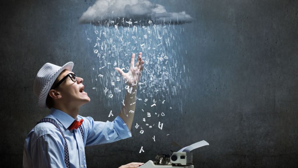 A spectacled man sitting at a typewriter and staring at a gray cloud above his head that is raining down letters